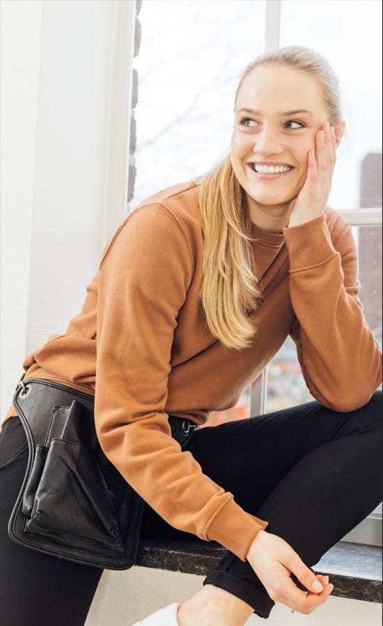 Sweater op terras met buidel 10 accessoires trends 2020